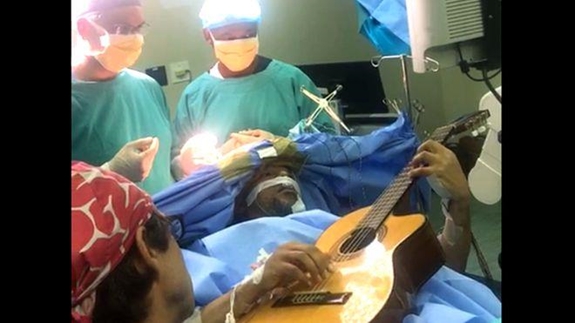 Manzini chơi ghi ta trong ca phẫu thuật. Ảnh: BBC.